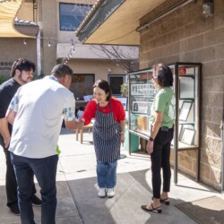a man in white shaking hands a bowing to a woman in red