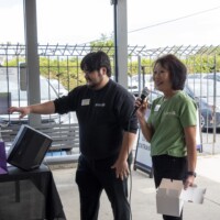 a man in black and a woman in green smiling