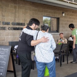 a woman in white side hugging a man in black