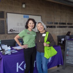 a woman in green posing with a woman in brown