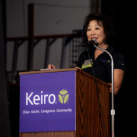 Beverly Ito talking in front of podium