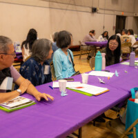 a group of people talking by a purple table