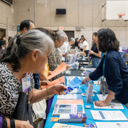 people looking at pamphlets by a blue table