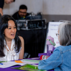 Gail Hirami talking with a woman in jean jacket