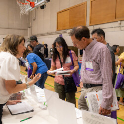 a woman in white talking to a group of people