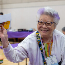 a woman with purple hair smiling with a gift card