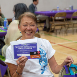 a woman in white smiling with a gift certificate