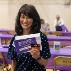 smiling woman holding an estate planning gift certificate and Yama gift card
