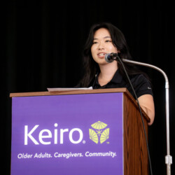 Charlene Tonai Din in black talking in front a podium