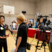 Bevely Ito in black talking in front of a camera crew