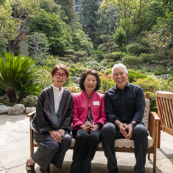 Beverly Ito smiling with two other people on a bench