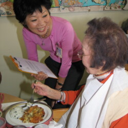 Beverly Ito smiling with a resident, 2006