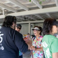 a man in a black sweater talking to a woman in floral