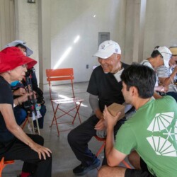 a man in green talking to a a woman in a red hat and white hat