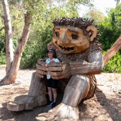 a woman in the hands of a wooden troll