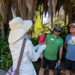 a woman in white taking a photo of two men