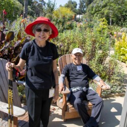 a man sitting down in a chair and a woman in a red hat standing