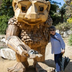a woman posing next to a wooden troll