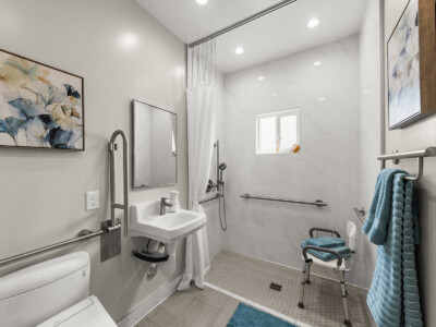 bathroom with ADA compliant shower and chair