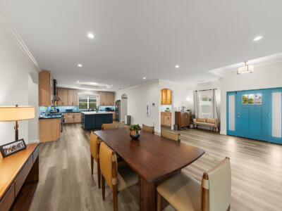 wide shot of the living room, kitchen, and blue front door.