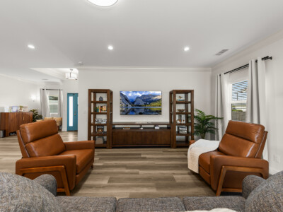 living room area with chairs and television on the wall