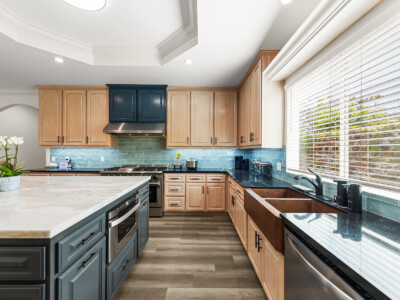 large kitchen with kitchen island and blue tiles with brown cabinets