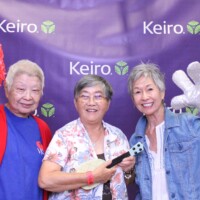 three women posing at photo booth with props