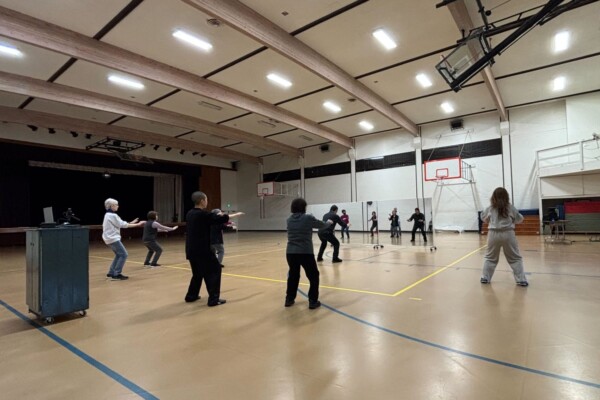large gym of people doing tai chi