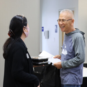 two people smiling and talking to each other