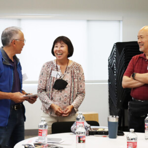 three people smiling and talking to each other