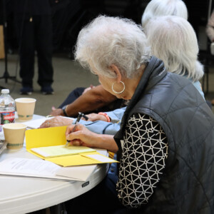 woman sitting down writing on a notepad