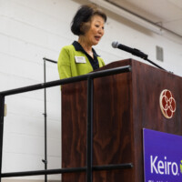 a woman in green talking at the podium