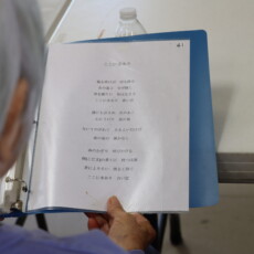 woman reading from binder with Japanese song lyrics