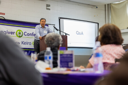 a man in a blue button down talking on a podium