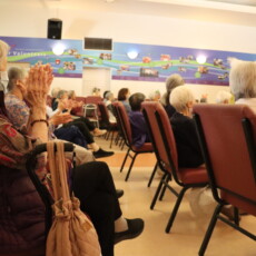 group of people clapping while sitting in chairs