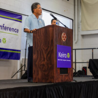 a man in blue talking on a podium