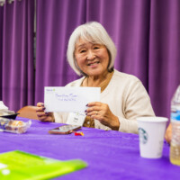 a woman in beige holding up an envelope
