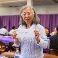 a woman in a blue sweater holding an envelope