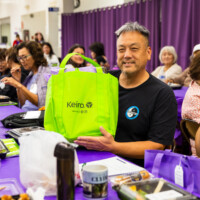 a man in black holding a green bag