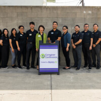 a group photo of Keiro's staff with the Caregiver Conference sign