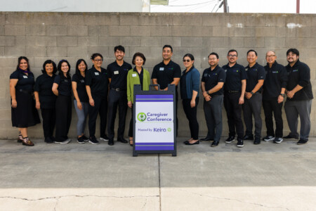 a group photo of Keiro's staff with the Caregiver Conference sign