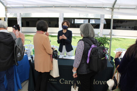 woman speaking to two people at information table