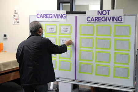 man putting card on board for caregiving activity