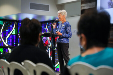 woman talking into microphone to crowd