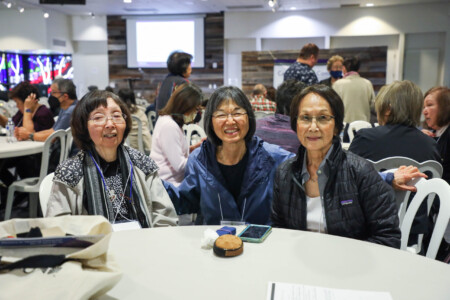 three women sitting and smiling at a table