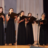 M PALMA PHOTO 2025 six women in choir on stage holding binders singing