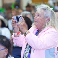 M PALMA PHOTO 2025 A woman standing in crowd taking picture on phone