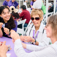 M PALMA PHOTO 2025 volunteer helping two attendees with origami