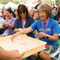 M PALMA PHOTO 2025 woman in crowd grabbing mochi from tray