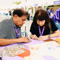 M PALMA PHOTO 2025 man and woman folding origami at table